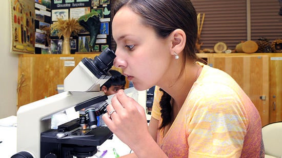 student looking through microscope (c) UCR / CNAS